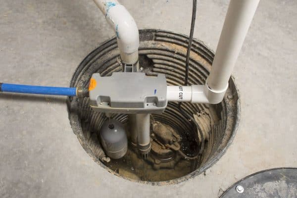 A sump pump installed in a basement of a home with a water powered backup system, How Long Does It Take To Install A Sump Pump? [Inc. New Install & Replacement]